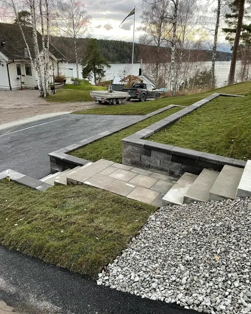 Stentrappa, grus och gräsyta vid ett hus